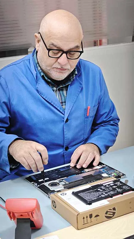 Técnico cambiando la batería de un portátil en el laboratorio de Laboprinter.