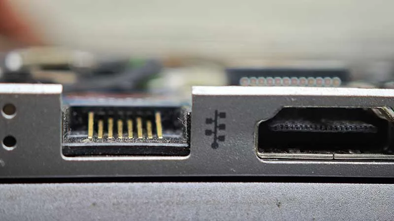 Conector de red RJ45 de portátil con pines dañados y aplastados.